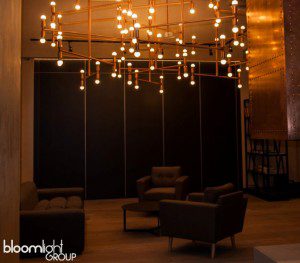 Rozbudowana lampa z rur miedzianych w lobby hotelowym w Trójmieście – unikalna instalacja oświetleniowa.