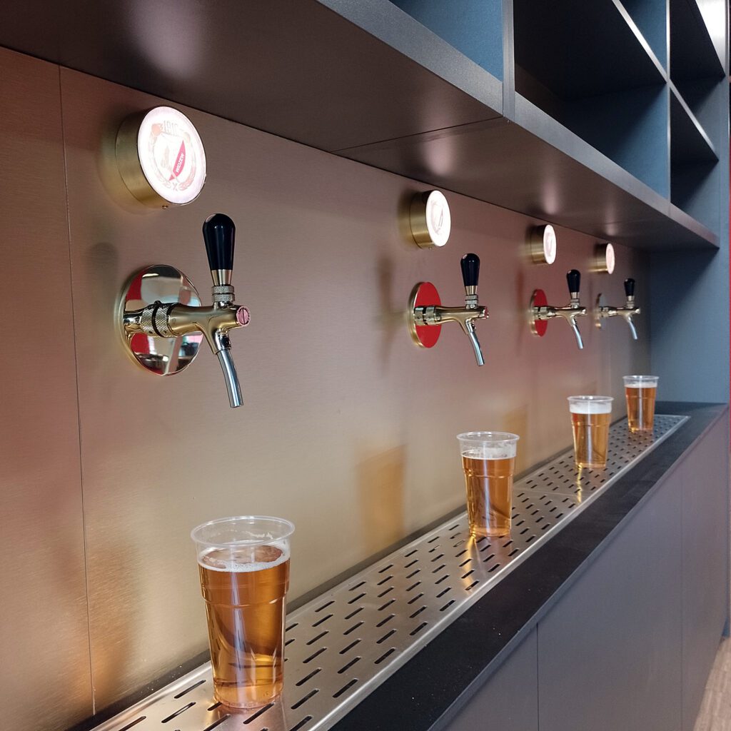 Podświetlane medaliony LED z brandingiem na ścianie piwnej – sala VIP Widzew Łódź.